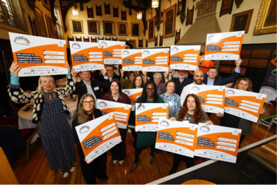 Taking Action - Group of people hold up the pledge